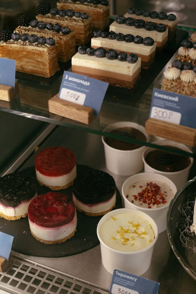 Close-up of assorted cakes and cheesecakes in a café display, perfect for dessert lovers.